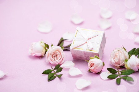 Rosebuds, petals,, gift box on a pink background. Concept for a greeting card. Weddings, Valentines Day, Birthdayの写真素材