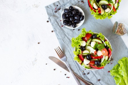 Appetizing greek salad in a plate on a served tableの写真素材