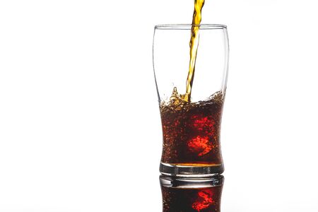 pouring cola into glass with ice on white background Copy spaceの写真素材