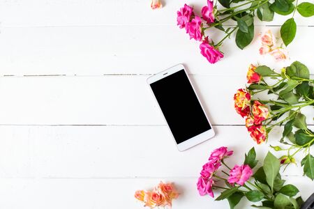 Smartphone, roses on the table. Women's things Fashion womens desk Top view Mockup Flat lay Copy spaceの写真素材