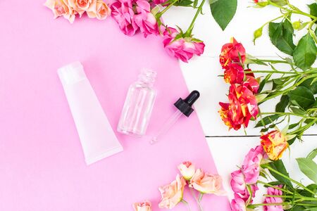 Crema Skincare Cosmetics with fresh roses. Essence, Oil on a pink and white desk. Beauty background Mock up Top view Flat layの写真素材