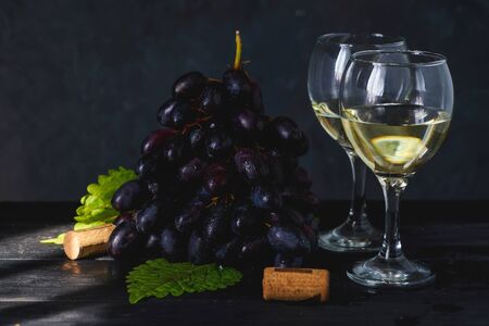 Black grapes, a glass of white wine on dark table Copy spaceの写真素材