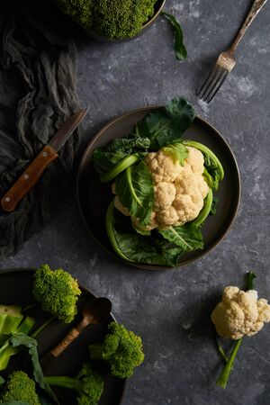 Organic cauliflower and broccoli on a plate on a dark backgroundの写真素材