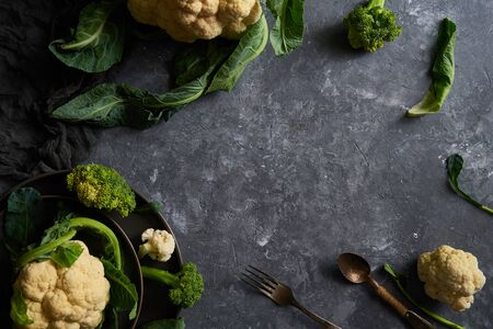 Organic cauliflower and broccoli on a plate on a dark background Copy space Top viewの写真素材
