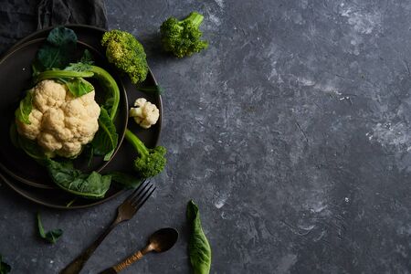 Organic cauliflower and broccoli on a plate on a dark background Copy space Top viewの写真素材