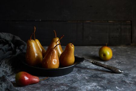 organic baked pears with honey in a plate on a dark backgroundの写真素材