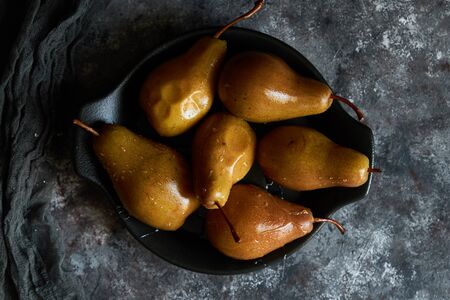Honey poured baked pears in a plate on a dark backgroundの写真素材