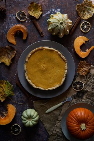 Pumpkin pie with cinnamon and vanilla on a plate. Autumn cozy concept. Dark background.の写真素材