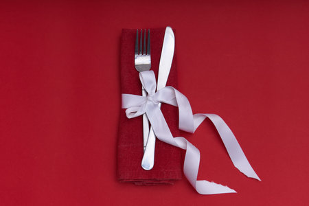 Valentines day concept. Silver cutlery with heart on red background Copy space