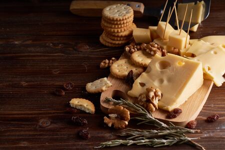 Pieces of cheese, nuts, raisins, snacks for wine on a wooden background. Appetitive Copy spaceの写真素材