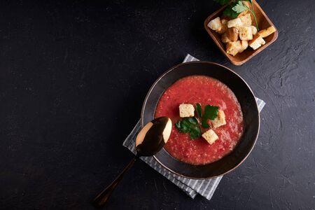 Homemade Spanish tomato soup Gazpacho with spice in black bowl on dark stone background Copy spaceの写真素材