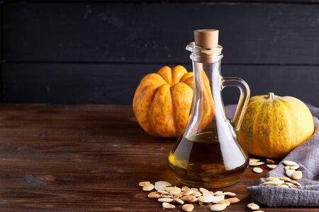 Healthy Pumpkin oil in glass bottles. Dark wooden background Copy spaceの写真素材