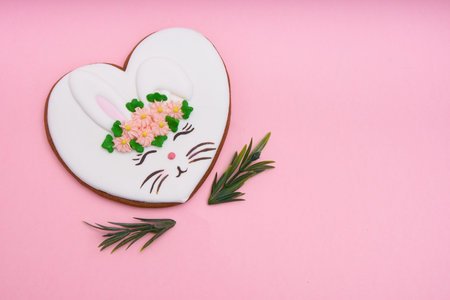 Easter bunny, gingerbread with glaze on pink background Copy space Top view