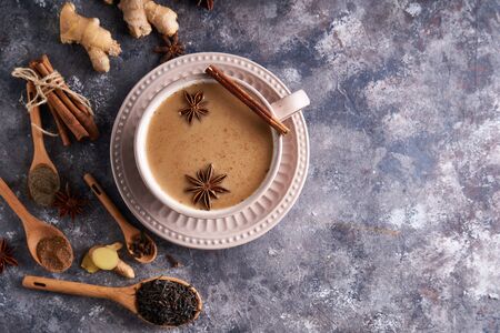 Masala tea in cup with spices ginger, cinnamon, anise, black pepper on gray sone background Copy spaceの写真素材