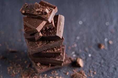 Piece of dark chocolate and chocolate chips on a dark background Dark table Copy spaceの写真素材