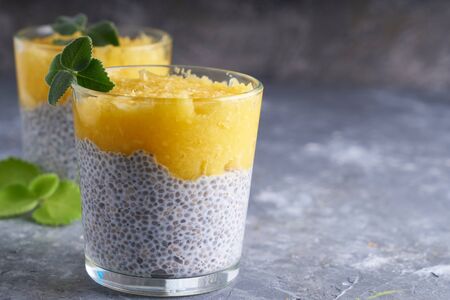 Chia pudding with mango and mint in glass on gray table Copy spaceの写真素材