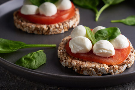 toasts with mozzarella, tomatoes and spinach in a gray plate Close up