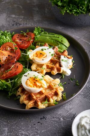 Healthy organic breakfast. Waffles, herbs, tomatoes,salad,eggs, spices served in a plate Close upの写真素材