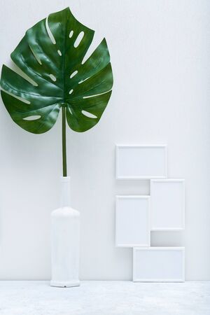 Stylish white mock up with vertical poster and plant in a vase Home Interiorの写真素材