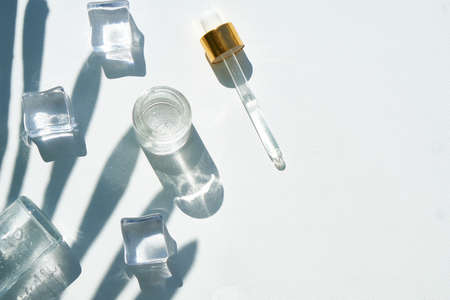 Cosmetic bubble with a dropper on a background of beautiful palm shadows Mock upの写真素材