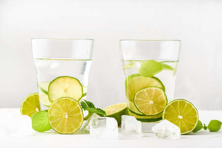Drink glasses with water, lime, mint and ice on white background Close upの写真素材