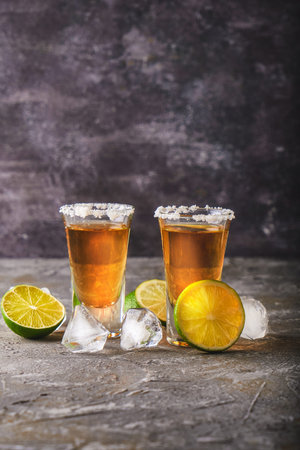 Appetizing tequila with lime and salt in a glass with ice Copy space