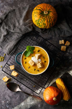 Traditional pumpkin soup puree with crackers, cream and seeds in a bowl, on a dark background Copy spaceの写真素材