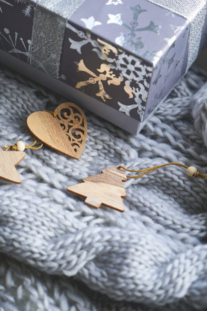 Christmas gifts and wooden souvenirs on knitted gray blanket Close up Copy space