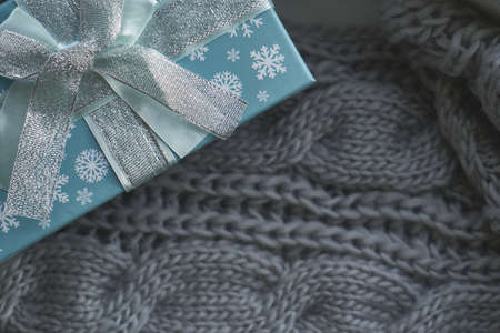 Christmas gifts on knitted gray blanket Close upの写真素材