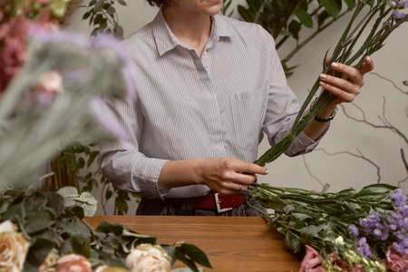 young woman florist in her studio makes a beautiful bouquet. Working moments Selective focusの写真素材