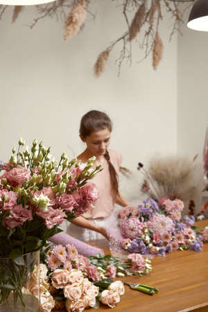 young woman florist in her studio makes a beautiful bouquet. Working moments Selective focusの写真素材
