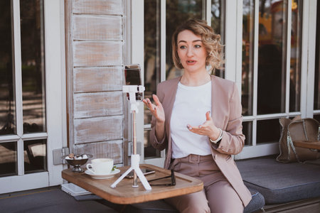 Stylish business woman in a street cafe working on laptop
