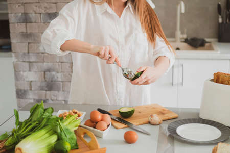 Young Beautiful girl in the kitchen prepares healthy food Close up of female handsの写真素材