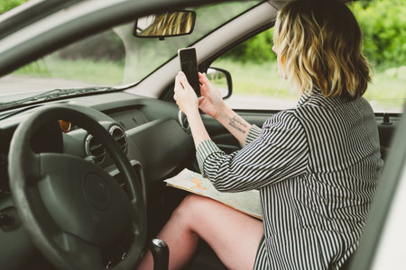 Happy young woman travels by car on the road.