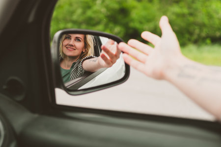 Happy young woman travels by car on the road.