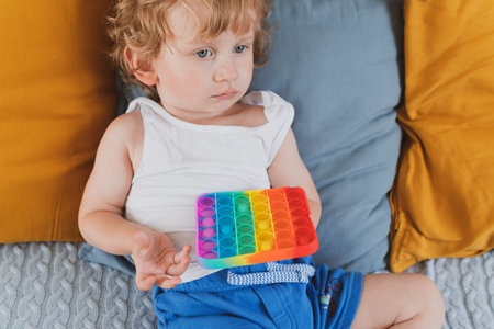 little boy holding anti stress sensory toys in his hand Young toddler playing with fidget sensory...