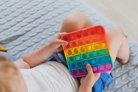 little boy holding anti stress sensory toys in his hand Young toddler playing with fidget sensory toyの写真素材
