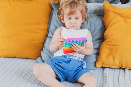 little boy holding anti stress sensory toys in his hand Young toddler playing with fidget sensory toyの写真素材