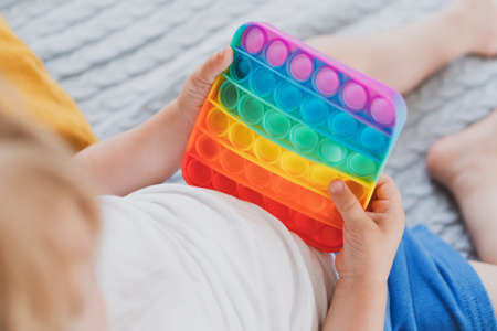 little boy holding anti stress sensory toys in his hand Young toddler playing with fidget sensory toyの写真素材