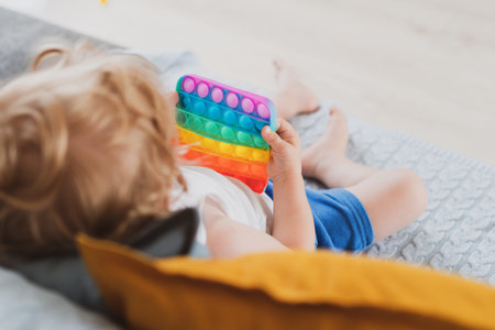 little boy holding anti stress sensory toys in his hand Young toddler playing with fidget sensory...