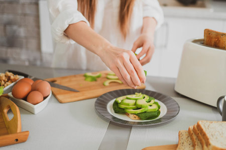 Beautiful young woman in the kitchen at home prepares healthy food