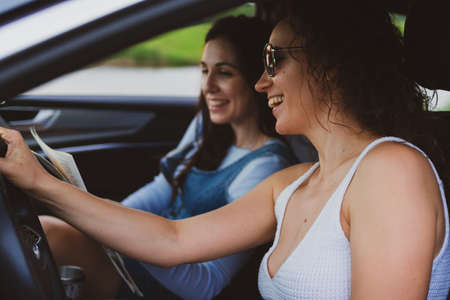 two young women travel the roads in a car. Vacation concept.の写真素材