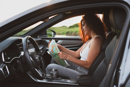 beautiful young woman travel on the roads by car, stopped at the side of the road and look at the...