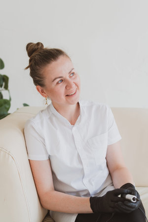 Permanent make-up master, tattoo master, beautician with permanent make-up toolの写真素材