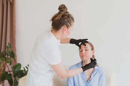 Eyebrow master, beautician models the eyebrows of a young womanの写真素材