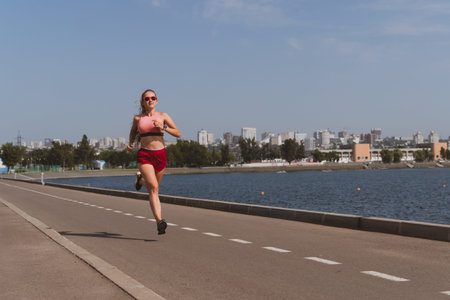 blondy sportive woman with long hair doing stretching in the park before jogging