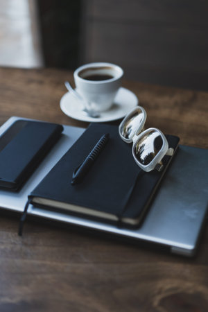 Desktop with laptop, notepad, phone and sunglasses