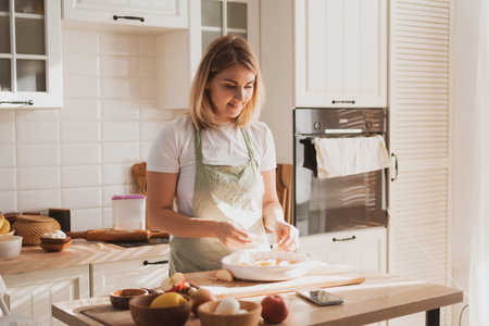charming young woman in chefs apron preparing pie at home in the kitchen Cozy home interior