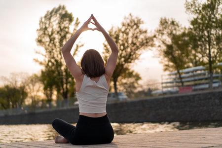 Young woman doing yoga by the lakeの写真素材
