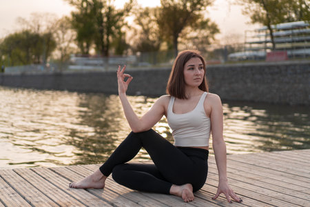Young woman doing yoga by the lakeの写真素材